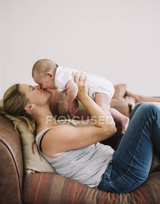 Frau küsst Baby Mädchen. — Stockfoto