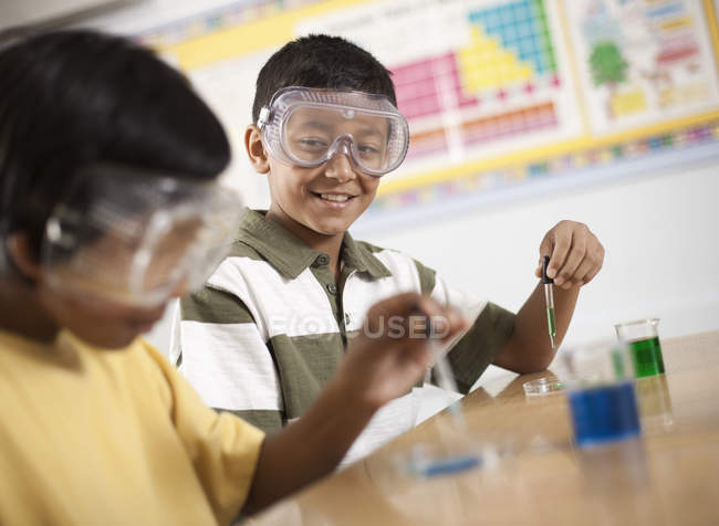 Niño y niña en una lección de ciencias - foto de stock