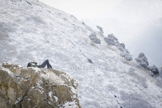 Uomo sdraiato su una roccia — Foto stock