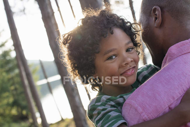 Homme portant un enfant dans les bras — Photo de stock