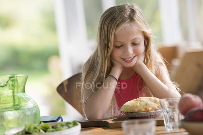 Дівчина дивиться на кондитерський пиріг — стокове фото