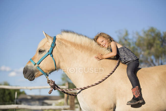Mädchen auf Pferd sitzend — Stockfoto
