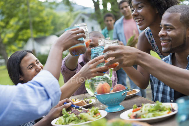 Personas en una comida en el jardín de una granja . - foto de stock