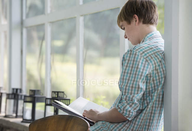Adolescent lisant un livre . — Photo de stock
