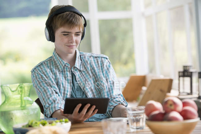 Ragazzo che ascolta musica con tablet digitale
. — Foto stock