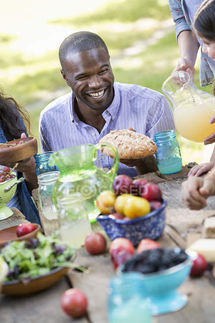Adults and children eating in a garden. — Stock Photo