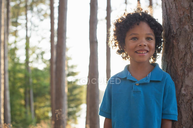 Bambino in piedi tra gli alberi — Foto stock