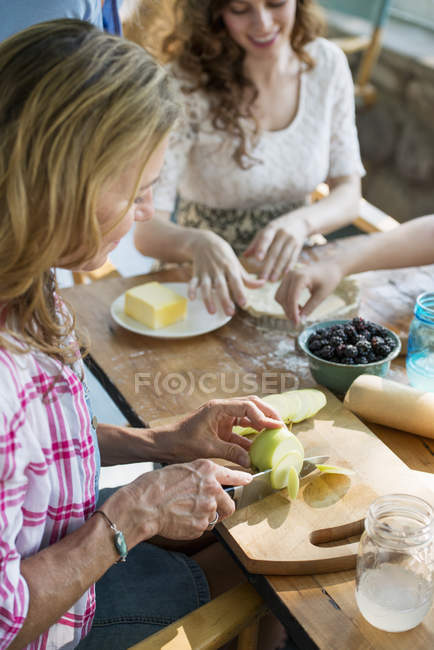Frauen backen Plätzchen und Apfelkuchen. — Stockfoto