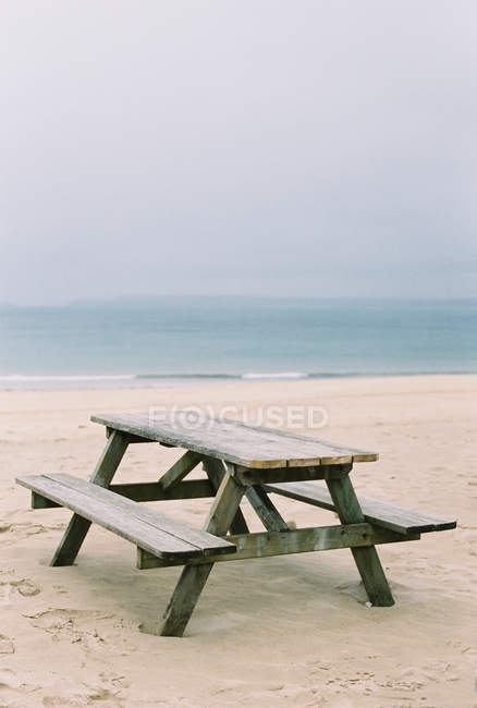 Деревянная скамейка для пикника на песке . — стоковое фото