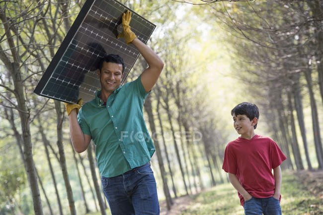 Uomo con un pannello solare — Foto stock