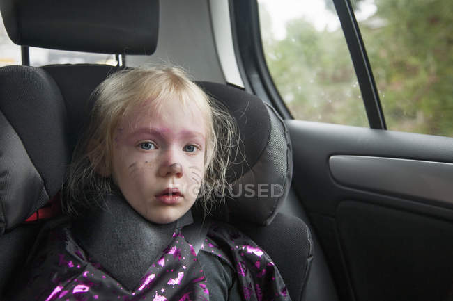 Chica en un asiento de coche en disfraz de Halloween . - foto de stock