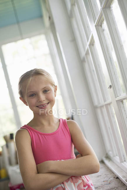 Menina em uma cozinha usando um vestido rosa . — Fotografia de Stock