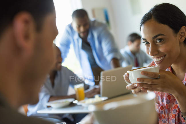 Hombres y mujeres en un café tomando bebidas - foto de stock