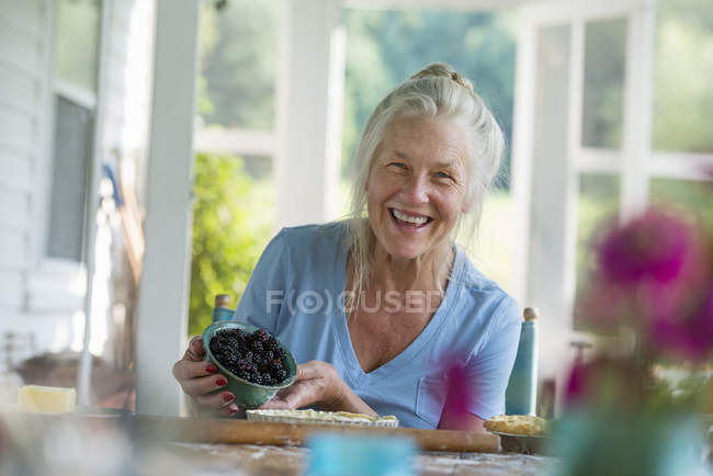 Женщина, держащая чашу с черными ягодами — стоковое фото