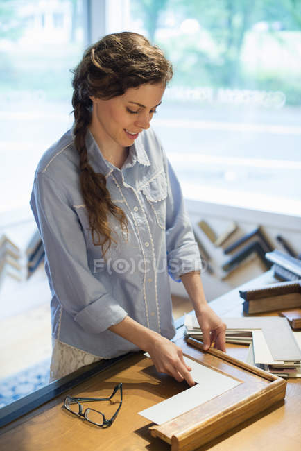Жінка вибирає рамки і картонні установки — стокове фото
