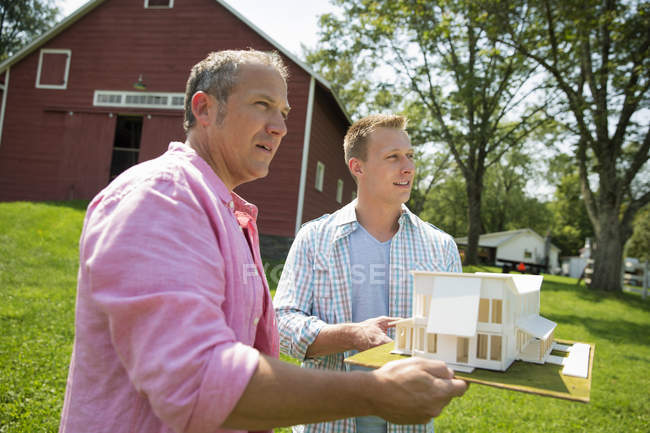 Двое мужчин держат модель дома — стоковое фото