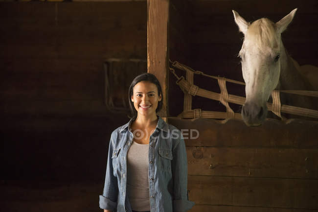 Woman standing in stable — Stock Photo