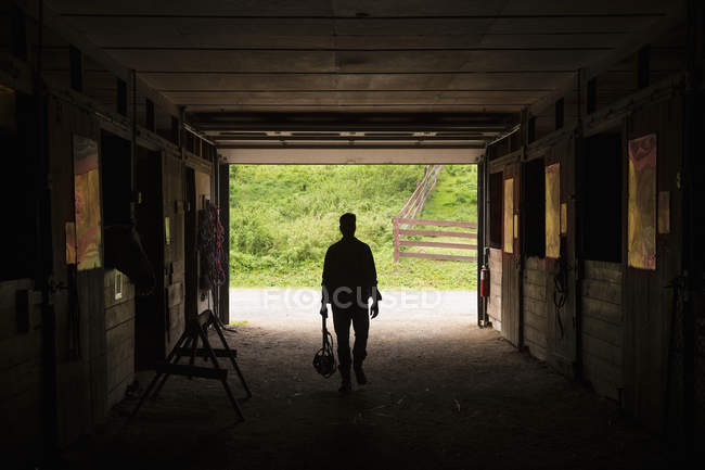 Man walking through stable — Stock Photo