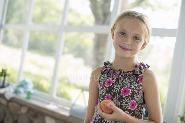 Mädchen mit einer Pfirsichfrucht — Stockfoto