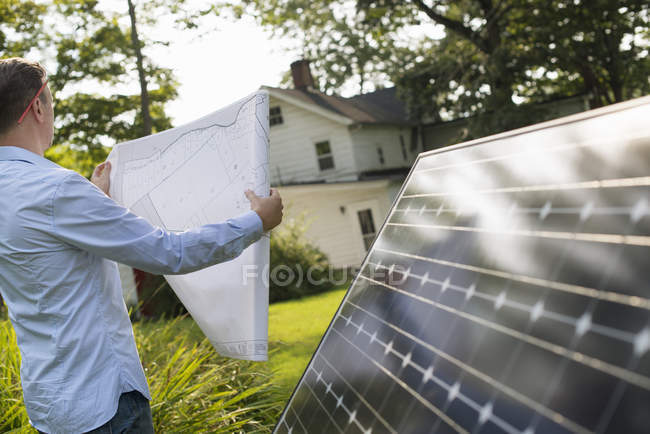 Hombre con panel solar - foto de stock