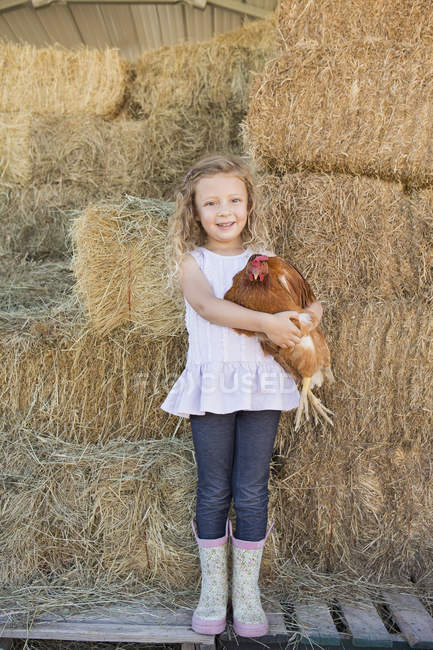 Chica sosteniendo pollo - foto de stock