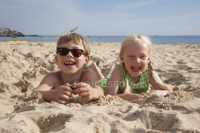 Ragazzo e ragazza sdraiati sulla sabbia — Foto stock