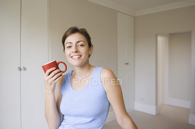 Donna che tiene una tazza rossa . — Foto stock