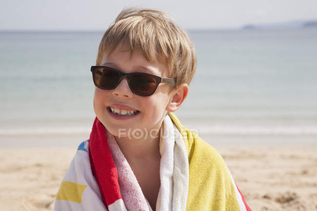 Niño en gafas de sol en la playa - foto de stock