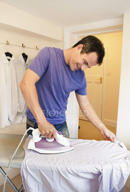 Homme repassage une chemise — Photo de stock