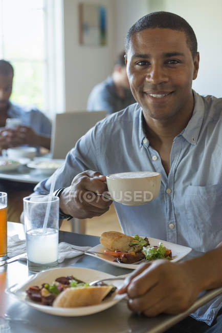 Человек ест и пьет в кафе — стоковое фото