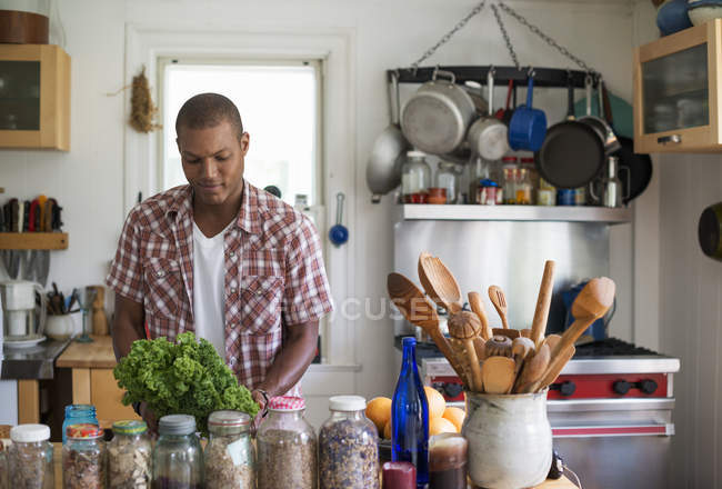 Людина в кухні, готуючи салат з листя — стокове фото