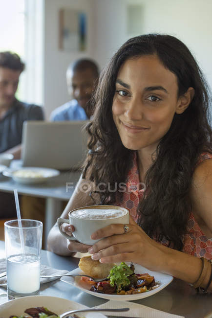 Женщина в кафе пьет кофе — стоковое фото