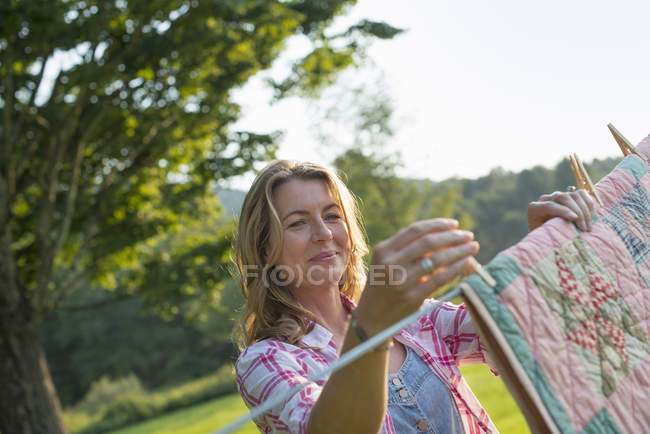 Mulher pendurado lavanderia na linha de lavagem — Fotografia de Stock
