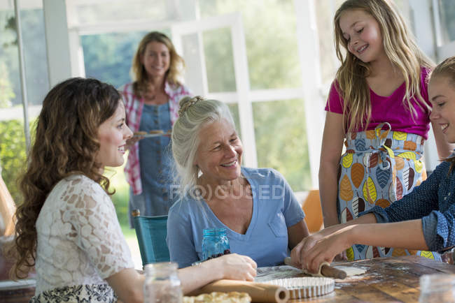 Четыре поколения женщин пекут вместе . — стоковое фото