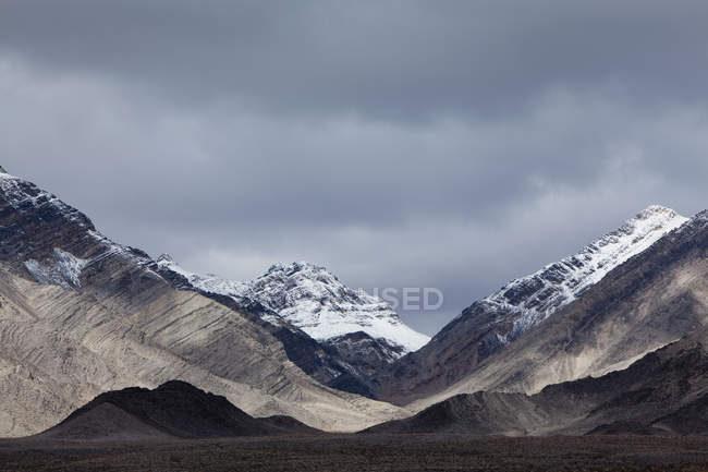 Montañas cubiertas de nieve y un cielo ominoso - foto de stock