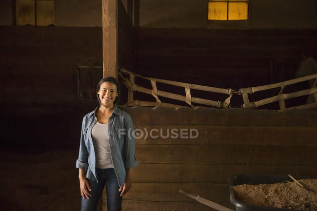 Woman in horse stable — Stock Photo
