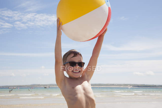 Хлопчик на пляжі з м'ячем — стокове фото