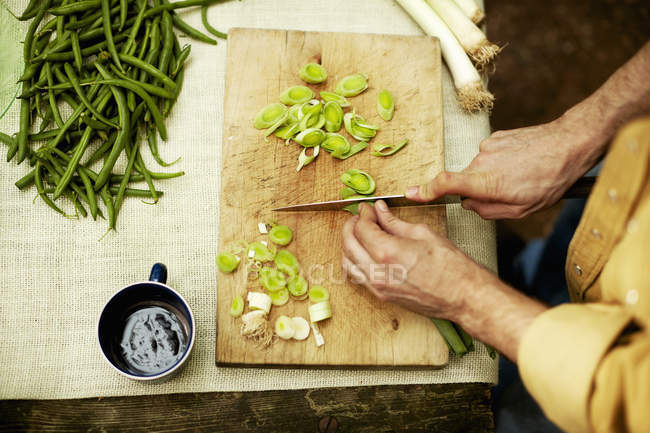 Man slicing spring onions — Stock Photo