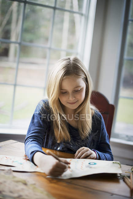 Menina desenho em um grande pedaço de papel . — Fotografia de Stock