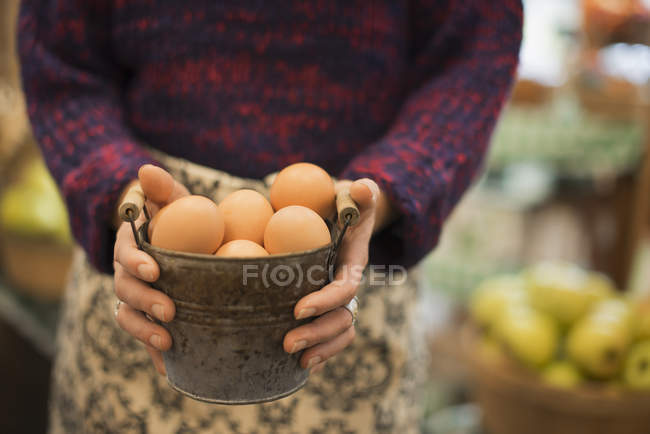 Frau trägt ein Gefäß mit Eiern. — Stockfoto
