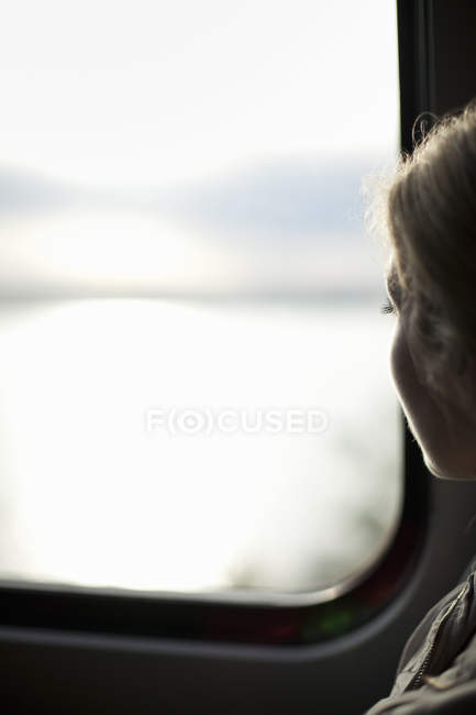 Женщина, сидящая у окна поезда — стоковое фото