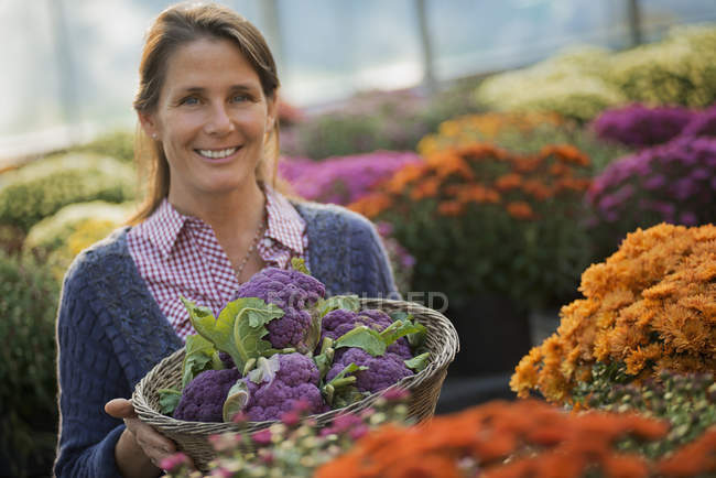 Woman holding purple sprouting broccoli. — Stock Photo
