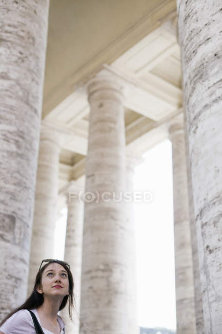 Femme levant les yeux vers les grands piliers — Photo de stock