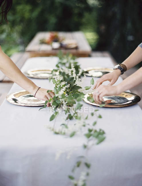 Besteck und Teller auf eine Tischplatte legen. — Stockfoto