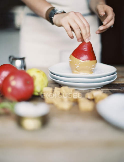 Immergere le pere fresche biologiche in una salsa — Foto stock