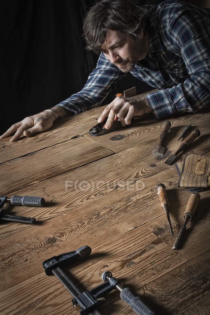 Mann arbeitet in einem aufbereiteten Bauholz — Stockfoto