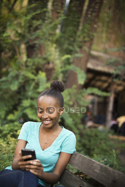 Jeune adolescente assise sur un banc — Photo de stock