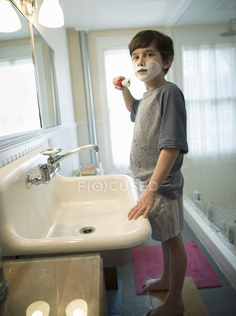 Jeune garçon debout dans la salle de bain — Photo de stock