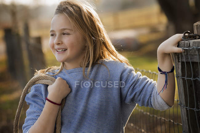Girl by a paddock fence. — Stock Photo