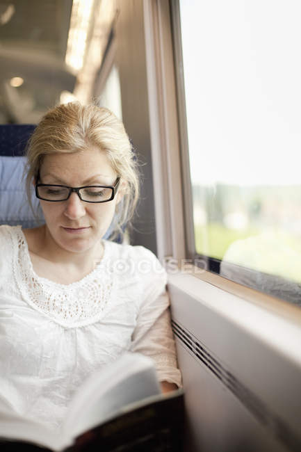 Woman sitting by a train window — Stock Photo
